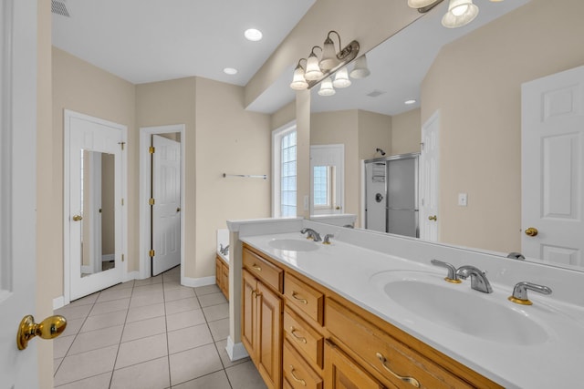 bathroom featuring double vanity, tile patterned flooring, a stall shower, and a sink