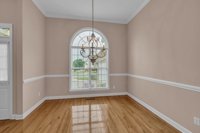 empty room featuring light wood finished floors, baseboards, a chandelier, and a healthy amount of sunlight
