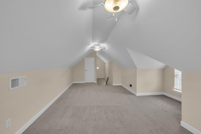 additional living space with visible vents, ceiling fan, vaulted ceiling, and carpet