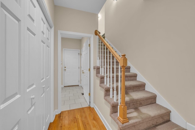 stairs featuring wood finished floors and baseboards