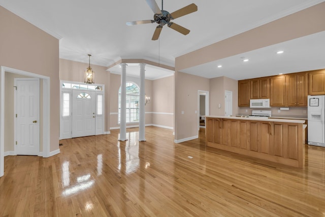 kitchen with decorative columns, ornamental molding, white appliances, and light countertops