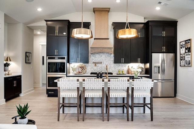 kitchen featuring a sink, appliances with stainless steel finishes, dark cabinetry, and visible vents