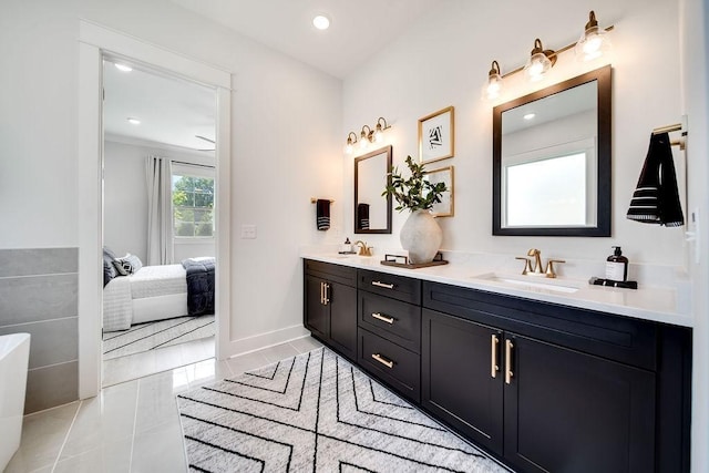 ensuite bathroom featuring double vanity, a sink, baseboards, connected bathroom, and recessed lighting