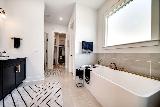 full bathroom featuring visible vents, a freestanding bath, tile patterned floors, a spacious closet, and a shower stall