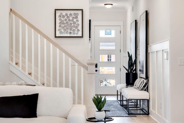 foyer with crown molding, tile patterned floors, and stairs
