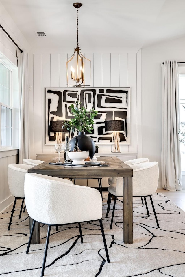 dining space featuring visible vents, light wood-style floors, and an inviting chandelier