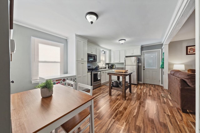 102 Lakeside Dr, Columbia, TN 38401 - kitchen featuring crown molding, a sink, stainless steel appliances, white cabinetry, and wood finished floors