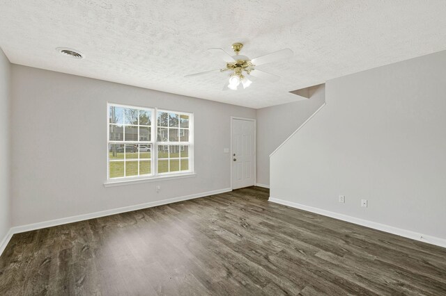 unfurnished living room featuring a textured ceiling, ceiling fan, visible vents, baseboards, and wood finished floors