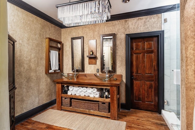 interior space with baseboards, ornamental molding, an inviting chandelier, and wood finished floors