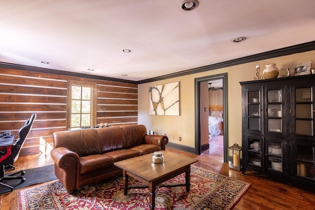 living room with wood finished floors, recessed lighting, ornamental molding, and baseboards