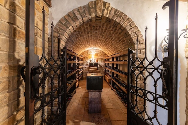 wine room featuring stone tile floors and vaulted ceiling
