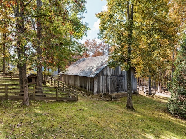 view of yard with an outdoor structure, a barn, and fence