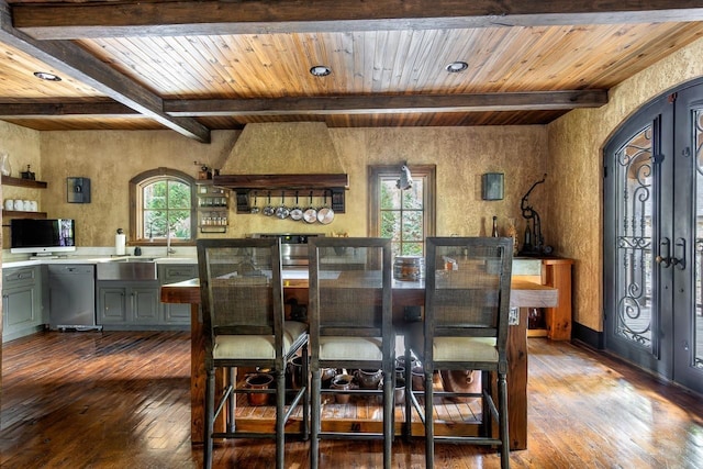 dining space with beamed ceiling, dark wood-style flooring, wooden ceiling, french doors, and plenty of natural light