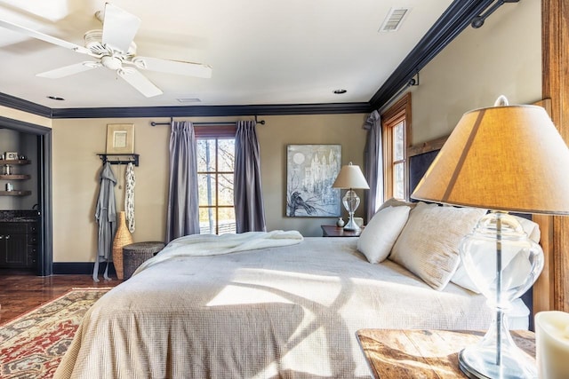 bedroom featuring ceiling fan, crown molding, visible vents, baseboards, and wood finished floors