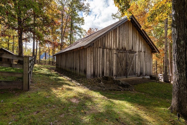 view of home's exterior featuring an outdoor structure, a yard, and fence
