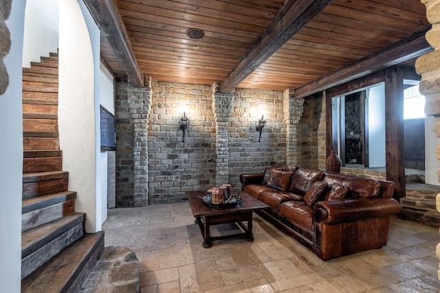 living area with stone tile floors, wooden ceiling, and stairway