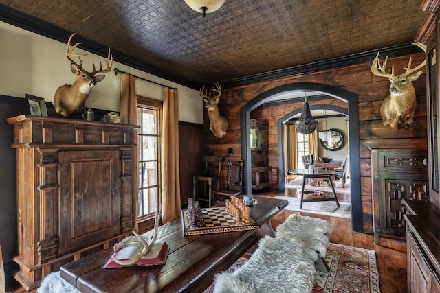 living area featuring ornamental molding, arched walkways, an ornate ceiling, and hardwood / wood-style flooring