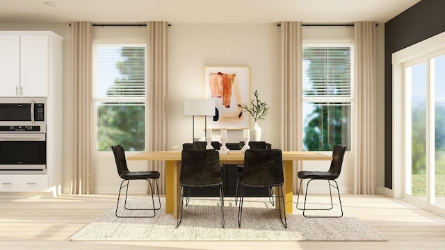 dining area with light wood-style flooring and baseboards
