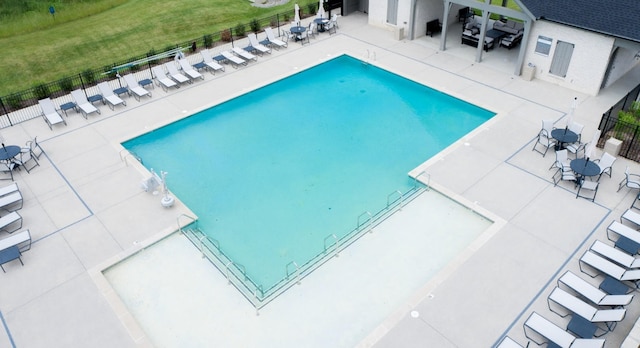 pool with fence, a lawn, and a patio