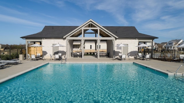 pool with a patio area and fence