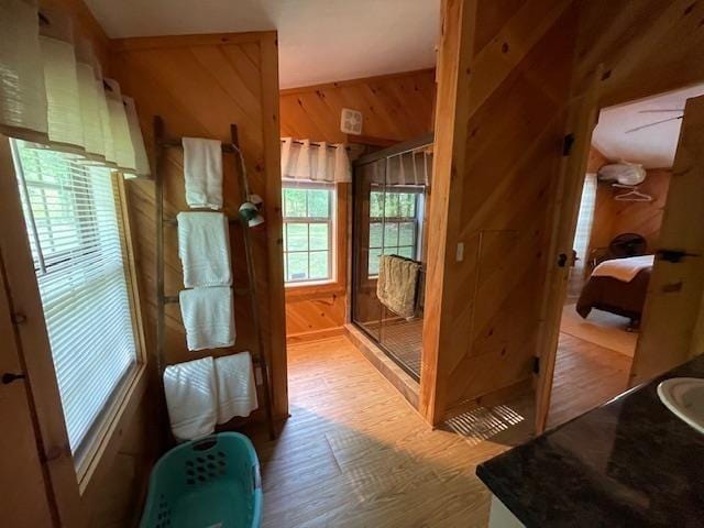 hall featuring wood finished floors and wooden walls