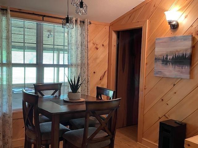 dining space featuring wood walls and an inviting chandelier