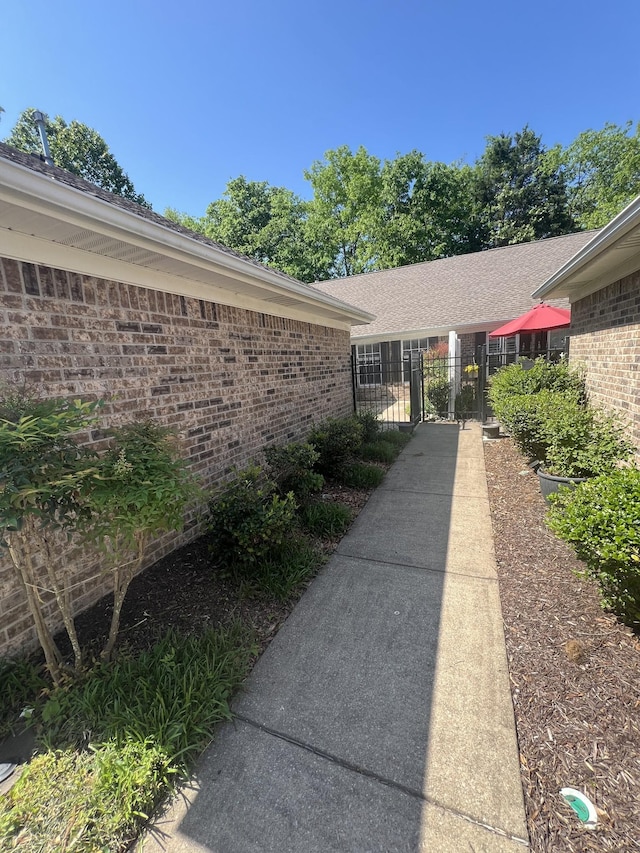 exterior space featuring fence, a gate, and brick siding