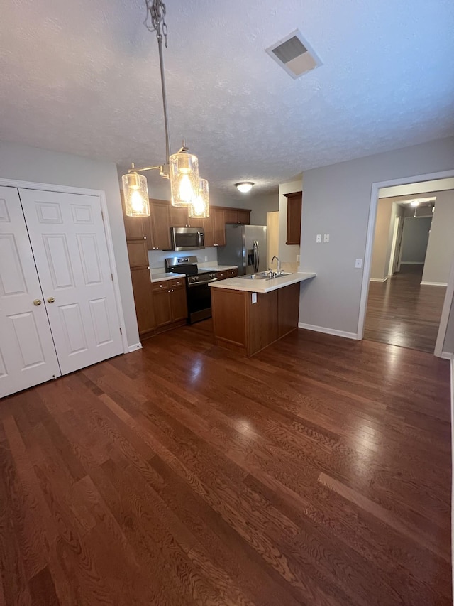800 Browns Ln Unit L2, Gallatin, TN 37066 - kitchen with a peninsula, dark wood-type flooring, baseboards, light countertops, and appliances with stainless steel finishes