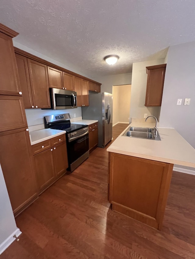 800 Browns Ln Unit L2, Gallatin, TN 37066 - kitchen featuring a peninsula, a sink, a textured ceiling, dark wood-type flooring, and appliances with stainless steel finishes