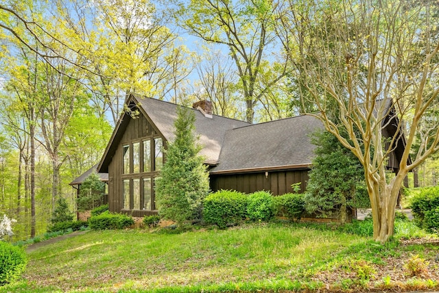 1331 Hutcheson Ln, Clarksville, TN 37040 - view of side of property with a chimney, board and batten siding, a yard, and roof with shingles