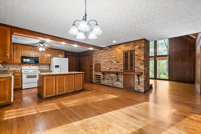 1331 Hutcheson Ln, Clarksville, TN 37040 - kitchen featuring wood walls, a center island, light wood-type flooring, white appliances, and brown cabinetry