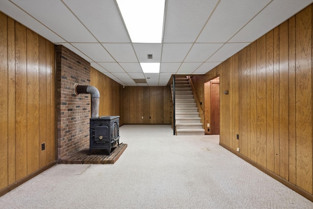1331 Hutcheson Ln, Clarksville, TN 37040 - finished basement featuring light colored carpet, stairway, wood walls, baseboards, and a wood stove