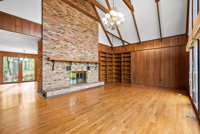 1331 Hutcheson Ln, Clarksville, TN 37040 - unfurnished living room with a chandelier, beam ceiling, wooden walls, high vaulted ceiling, and built in shelves
