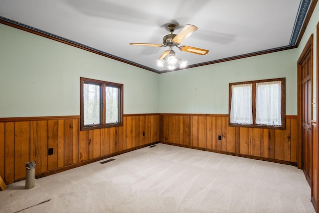 1331 Hutcheson Ln, Clarksville, TN 37040 - empty room featuring crown molding, wood walls, visible vents, a wainscoted wall, and a ceiling fan