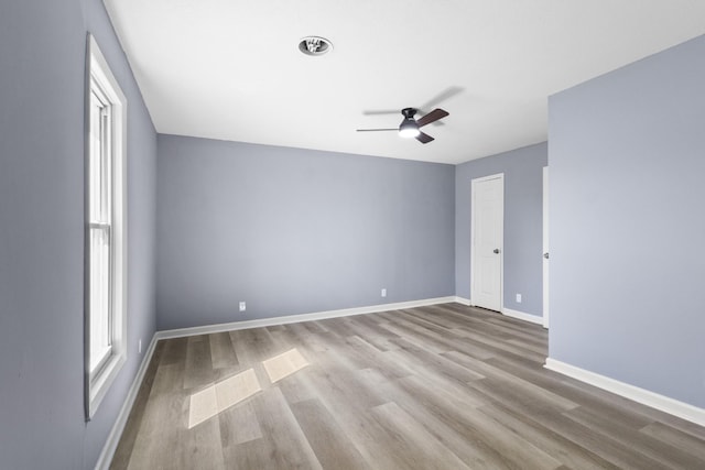 empty room with baseboards, wood finished floors, and a ceiling fan