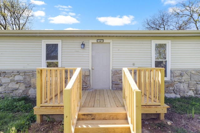 exterior space with a wooden deck and stone siding