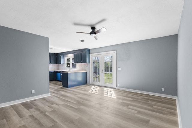 unfurnished living room with french doors, ceiling fan, light wood-style flooring, and baseboards