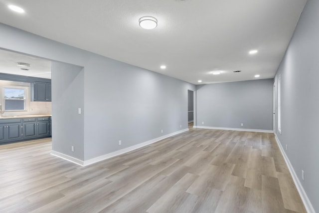 spare room featuring baseboards, recessed lighting, and light wood-style flooring