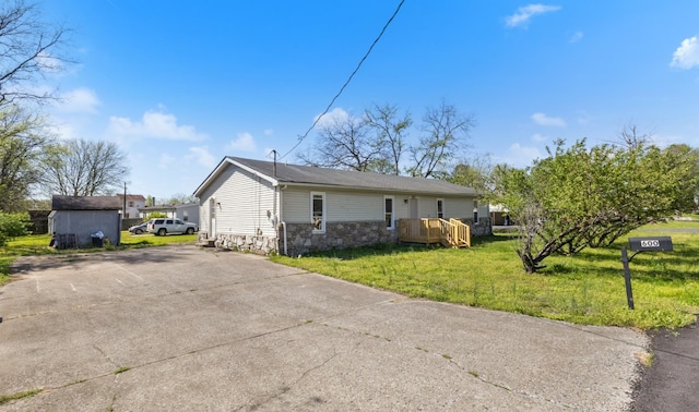 view of side of home featuring a yard and stone siding