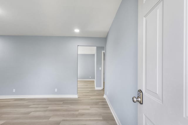 spare room with baseboards, recessed lighting, and light wood-style flooring