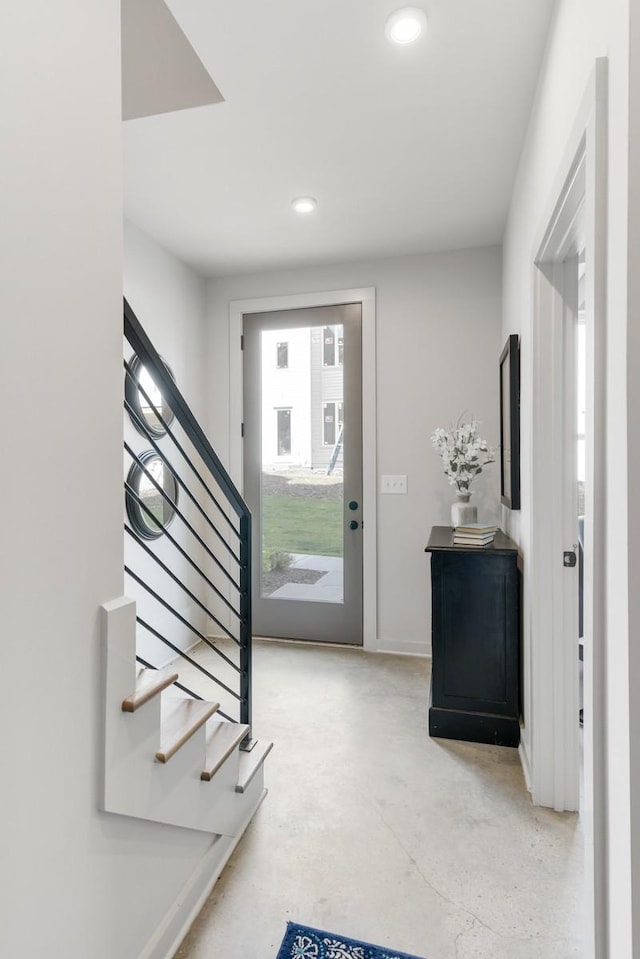 entryway with stairway, recessed lighting, and finished concrete floors