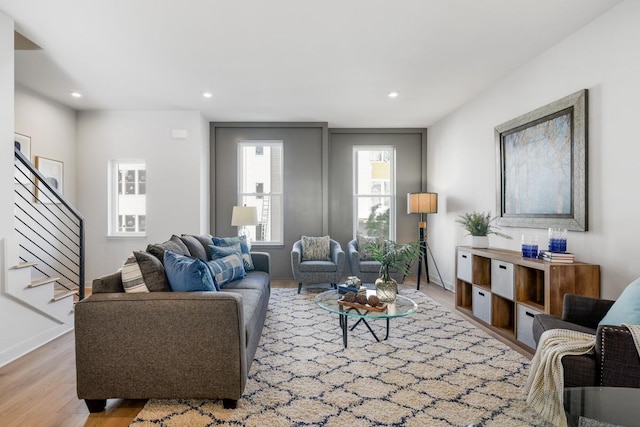 living room featuring baseboards, recessed lighting, stairs, and light wood finished floors