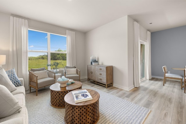 living area featuring baseboards and light wood-style floors