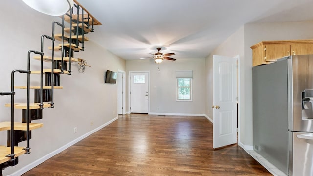 foyer entrance with baseboards, a ceiling fan, and dark wood-type flooring