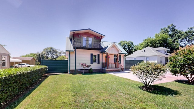 bungalow with a front yard, fence, crawl space, and a balcony