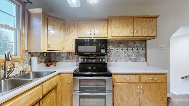 kitchen featuring light countertops, backsplash, a sink, range with two ovens, and black microwave