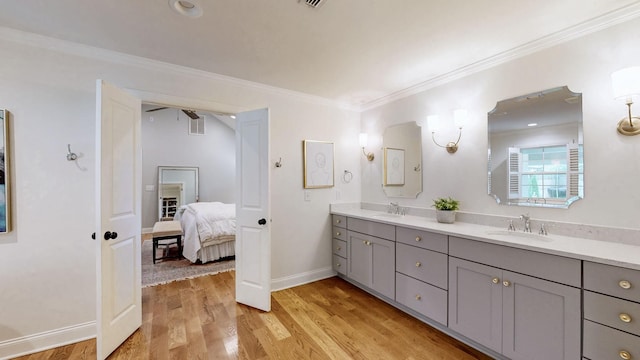 ensuite bathroom with wood finished floors, connected bathroom, visible vents, and a sink