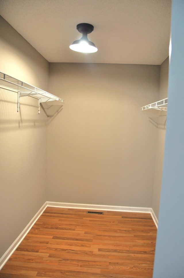 walk in closet with visible vents and wood finished floors
