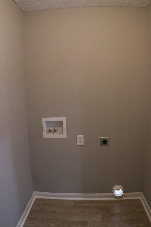 washroom featuring hookup for a washing machine, electric dryer hookup, wood finished floors, and baseboards