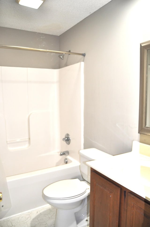 full bathroom featuring toilet, vanity, a textured ceiling, and bathing tub / shower combination
